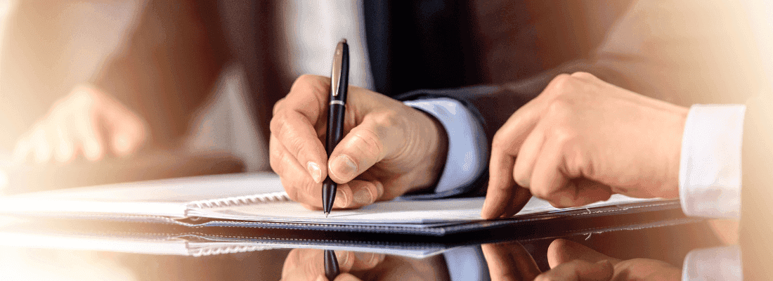 mężczyzna podpisujący dokumenty compliance